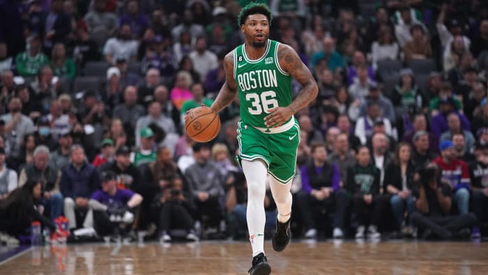 Boston Celtics guard Marcus Smart dribbles down the court in a green uniform